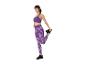 Femme s'étirant en brassière de sport et legging violets.