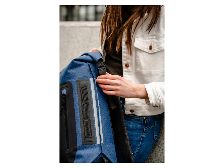 Sac à dos bleu marine et veste en jean blanche.