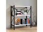 Une étagère en métal blanche avec des livres, des vases et des objets décoratifs.