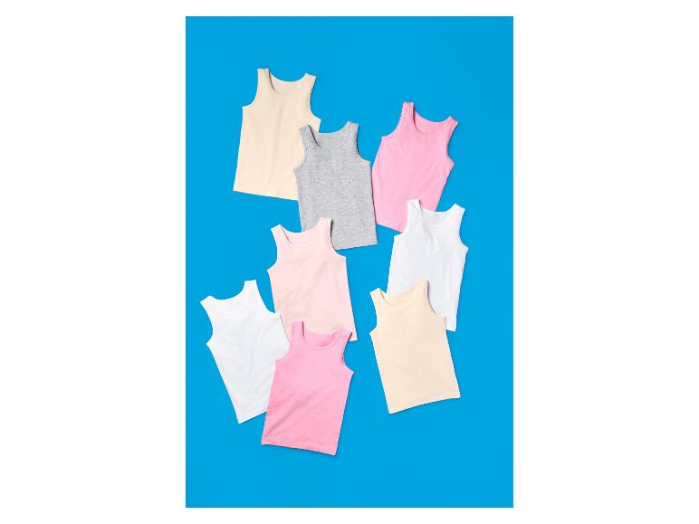 Débardeurs colorés pour enfants sur fond bleu.