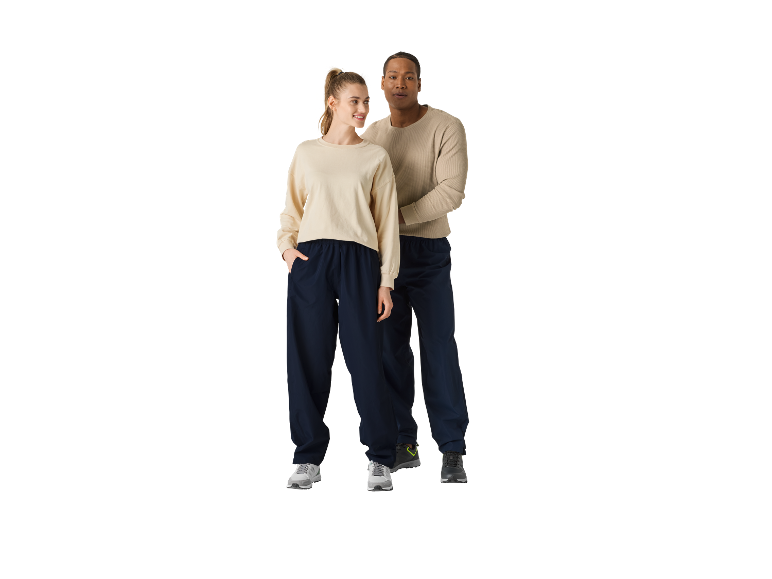 Couple en sweat-shirts beiges et pantalons de jogging bleu marine.