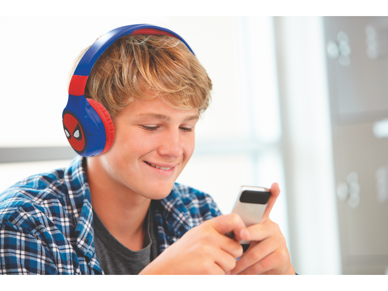 Adolescent avec un casque et une chemise à carreaux utilisant un smartphone.
