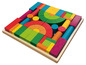 Blocs de bois de différentes formes et couleurs dans une boîte en bois.