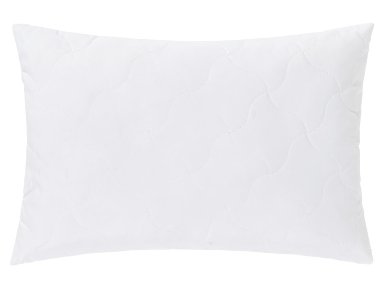 Un oreiller blanc avec un motif de piqûres courbes.