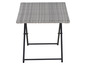 Une table à plateau en osier gris sur un piétement noir pliable.