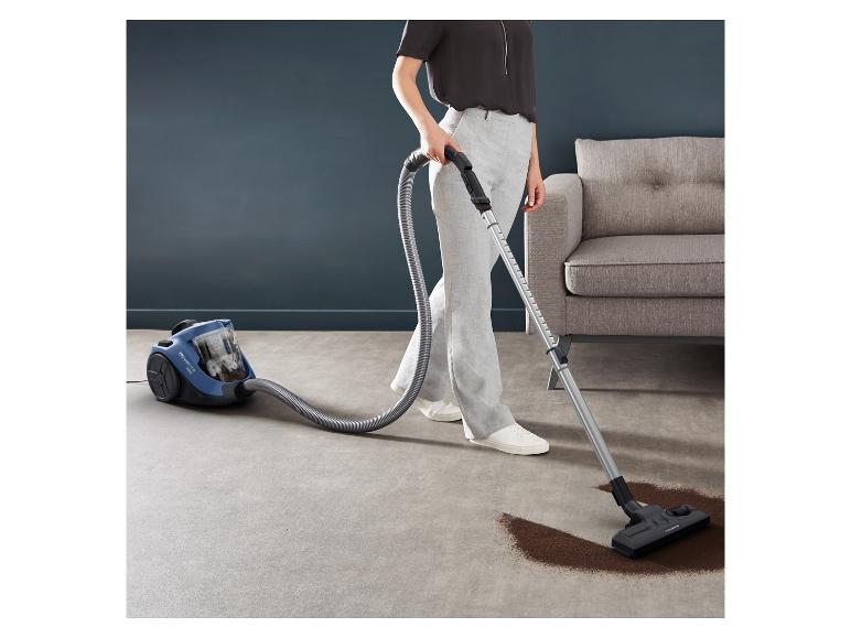 Une femme aspire avec un aspirateur Siemens.