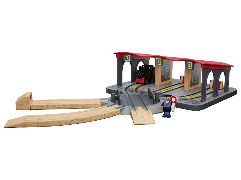 Ensemble de train en bois avec locomotive, gare et figurine de chef de gare.