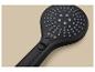 Pommeau de douche noir avec différents modes de jet sur fond beige.