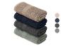 Pile de quatre serviettes pliées en beige, bleu marine, gris foncé et vert sauge.