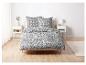 Un lit blanc avec un motif floral noir, y compris des oreillers.