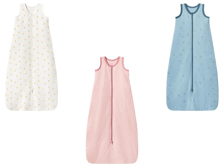 Trois gigoteuses bébé: blanche avec girafes, rose avec étoiles et bleue avec étoiles.