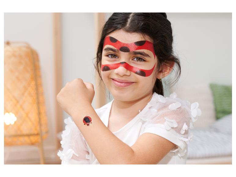 Une fille avec du maquillage et un tatouage de coccinelle.