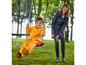 Un enfant dans un imperméable jaune et une femme dans un imperméable bleu, à l'extérieur dans le jardin.