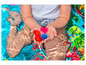 Un enfant dans une piscine avec des ballons d'eau colorés.