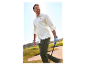 Homme en chemise blanche et pantalon vert jouant au golf.