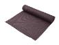 Un tapis de yoga brun foncé, partiellement enroulé.
