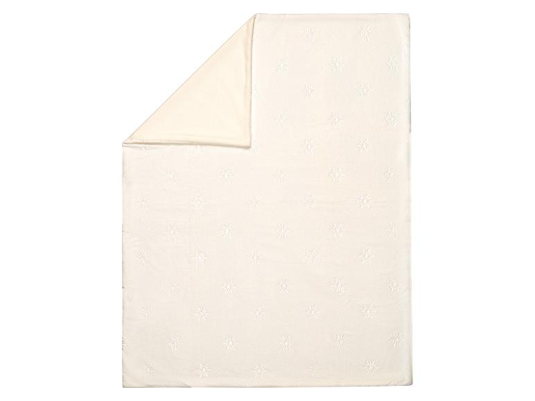 Couverture crème avec motif flocon de neige, pliée
