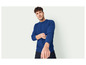 Un homme porte un pull bleu à manches longues.