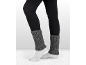 Femme portant des leggings noirs, des chaussettes blanches et des jambières grises tricotées.