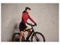 Une femme sur un vélo noir avec un casque.