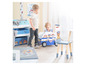Des enfants jouent avec une voiture de jouet Paw Patrol, une chaise et une armoire avec des tiroirs.