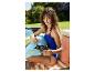 Une femme en maillot de bain gonfle un flotteur citron avec une pompe électrique.