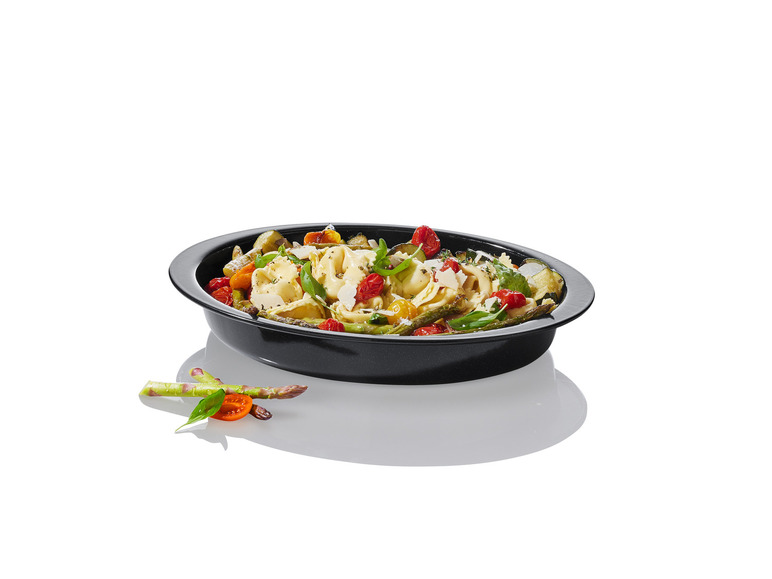 Tortellini avec des légumes dans un plat à four noir.