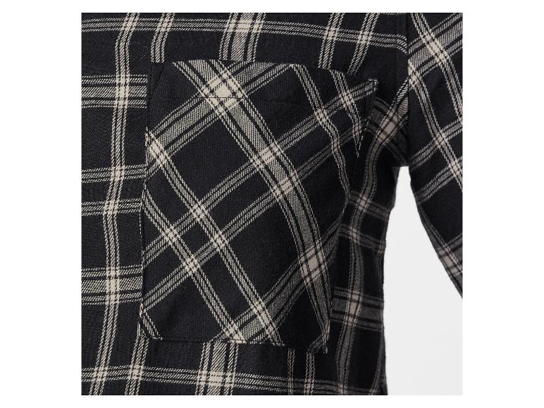 Une poche sur une chemise à carreaux noirs et beiges.