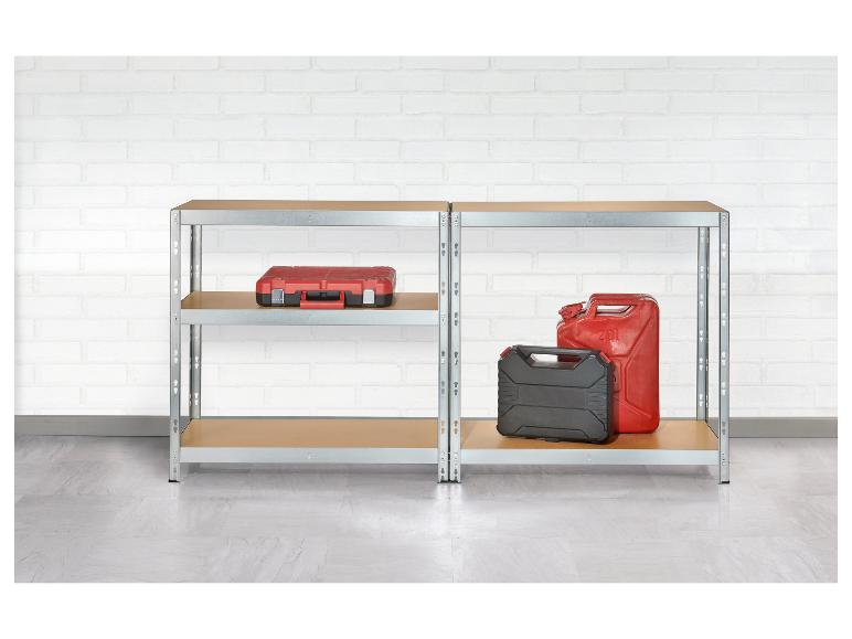 Étagères métalliques avec une boîte à outils rouge et des bidons sur un mur de briques blanches.