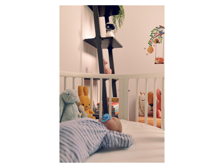 Chambre d'enfant avec babyphone et bébé endormi.