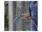 Un homme tient un nettoyeur haute pression Gardena avec une brosse et un tuyau.