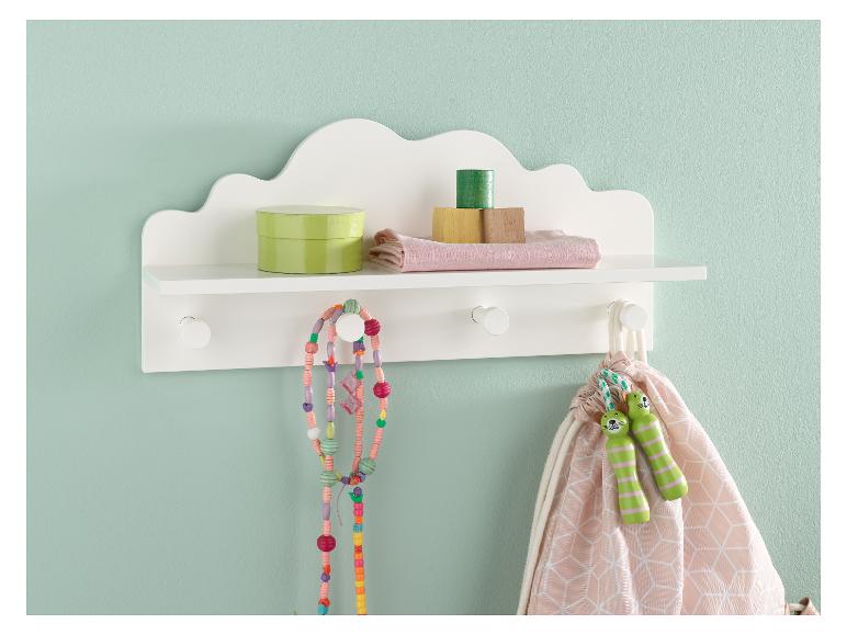 Une étagère en bois blanche avec une tablette et des crochets, avec des jouets comme des perles, des cordes à sauter et des blocs.