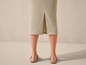 Une jupe midi beige avec une fente et des sandales beiges