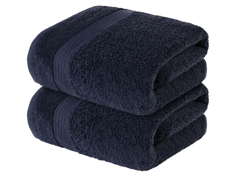 Deux serviettes de bain foncées, moelleuses et empilées.