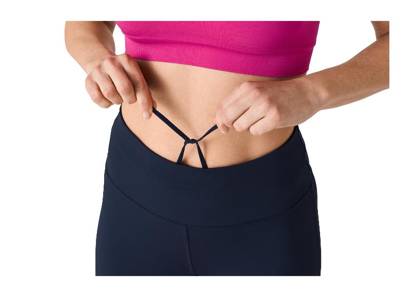 Femme ajustant les lacets d'un legging de sport et d'un haut rose.