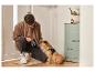 Un homme attache une laisse Superdog à son chien.