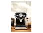 Machine à expresso noire et argentée avec tasses sur le dessus, sur un comptoir en bois.