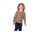 Enfant en pull marron et pantalon bleu foncé souriant.