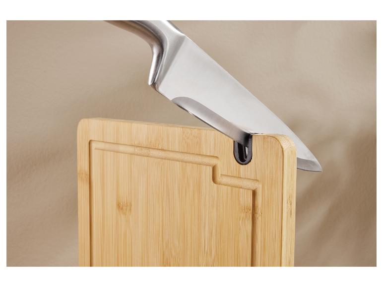 Couteau de cuisine dans une planche à découper en bambou.