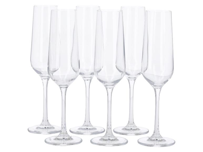 Six flûtes à champagne en verre transparent sur fond blanc.