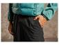 Gros plan sur un homme portant un pantalon noir et une veste verte.