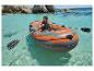 Un homme rame dans un bateau gonflable CRIVIT dans une eau claire.