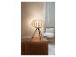 Une lampe de table en bois avec un abat-jour en osier sur un buffet en bois.
