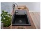 Cuisine moderne avec évier noir, plan de travail en bois et plante de menthe fraîche.