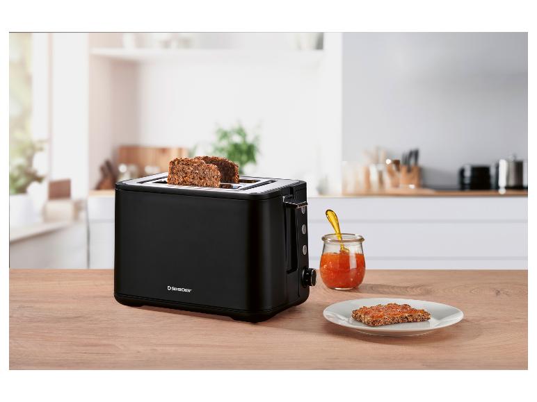 Grille-pain noir SilverCrest avec du pain grillé et de la confiture sur une table en bois.