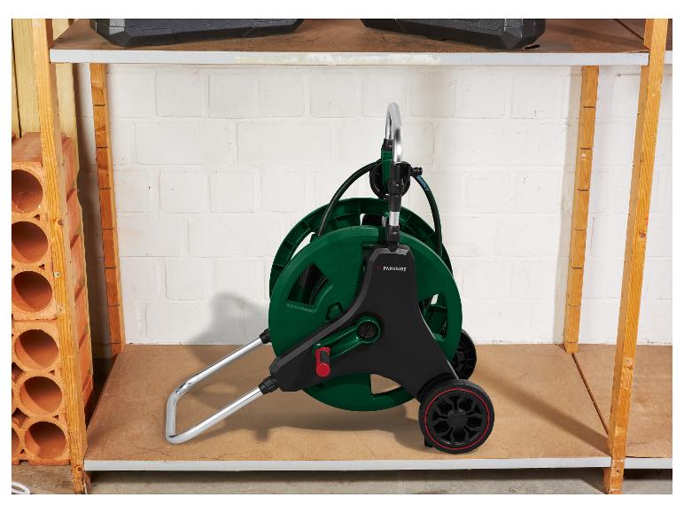 Dévidoir de tuyau PARKSIDE avec tuyau, sur une étagère dans un débarras.