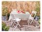 Table et chaises pliantes blanches, ambiance jardin.