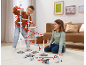 Des enfants jouent dans le salon avec un grand circuit à billes coloré.
