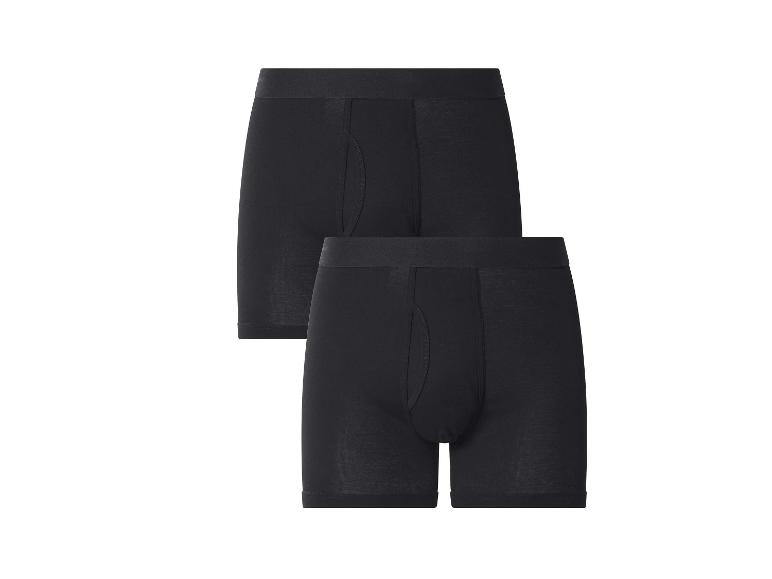 Deux boxers noirs pour hommes, l'un légèrement derrière l'autre.