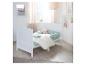 Lit d'enfant blanc avec literie vert menthe et oreillers étoiles dans une chambre d'enfant lumineuse.